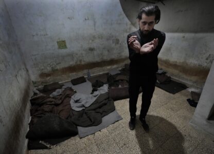 Abdullah Zahra demonstrates how he was tortured in a cell at Branch 215, a detention facility run by military intelligence during Bashar Assad's regime, in Damascus, Syria, on Tuesday, Dec. 17, 2024. (AP Photo/Hussein Malla)