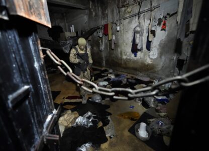 A member of the security forces for the new interim Syrian government inspects a cell of the Palestine Branch detention facility operated during Bashar Assad's regime, in Damascus, Syria, on Dec. 14, 2024. (AP Photo/Hussein Malla)