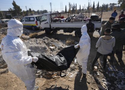 Members of the Syrian Civil Defense carry one of several bodies, and human remains, discovered near Damascus International Airport, in Damascus, Syria, on Dec. 16, 2024. (AP Photo/Hussein Malla)
