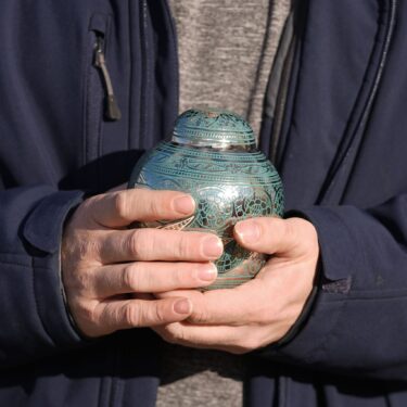 Eric Pranger holds an Urn that contains the ashes of Allen Livingston, Saturday, Dec. 21, 2024, in Westfield, Ind. (AP Photo/Darron Cummings)