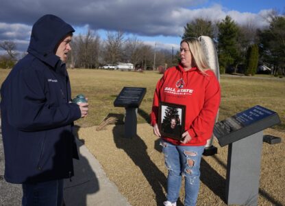 Eric Pranger and Shannon Doughty talk by a memorial, Saturday, Dec. 21, 2024, in Westfield, Ind. (AP Photo/Darron Cummings)