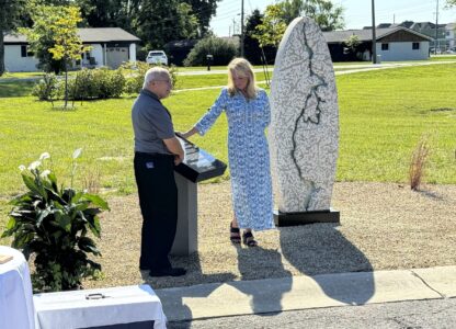 Hamilton County Coroner Jeff Jellison and Linda Znachko, founder of the nonprofit Indianapolis-based ministry He Knows Your Name, look at a marker on August 29, 2024, in Westfield, Indiana, that lists the names of the nine known victims of suspected serial killer Herbert Baumeister. (AP Photo/Rick Callahan)