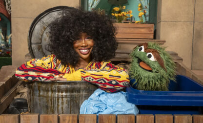 This image released by Sesame Workshop shows singer SZA, left, with muppet character Oscar the Grouch on the set of 