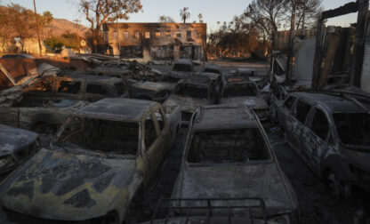 Cars sit at an auto repair shop after they were destroyed by the Eaton Fire in Altadena, Calif., Monday, Jan. 13, 2025. (AP Photo/Jae C. Hong)