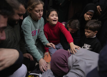 From center right, Younes 6, Isra' 10, Ala, 7 and Asma' 12, in green, cry while taking the last look at the body of their father Ahmad Ararawi, 37, wrapped with Islamic Jihad flag, during the funeral of six Palestinians who were killed during an Israeli airstrike on Wednesday, in the West Bank refugee camp of Jenin Thursday, Jan. 16, 2025. (AP Photo/Nasser Nasser)