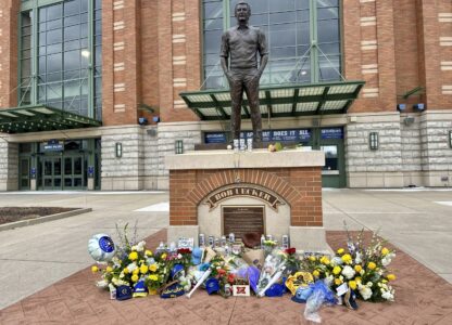 Items are left at the base of a statue of Bob Uecker outside American Family Field in Milwaukee, Thursday, Jan. 16, 2025. (AP Photo/Steve Megargee)