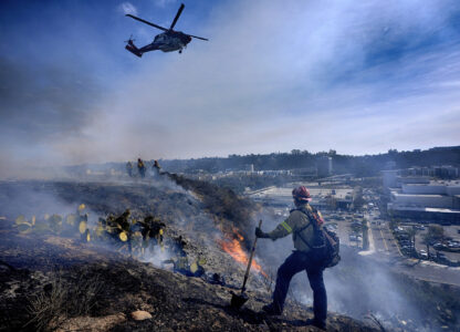 San Diego firefighters knock down a small brush along a hillside over the Mission Valley Shopping Mall in San Diego on Tuesday, Jan. 21, 2025. (AP Photo/Gregory Bull)