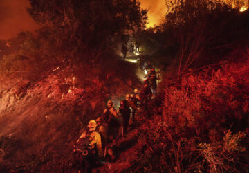 Firefighters walk up a ridge to battle the Lilac Fire in Bonsall, Calif., Tuesday, Jan. 21, 2025. (AP Photo/Jae C. Hong)
