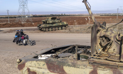 A family drives past tanks that belonged to the Assad government, in Nawa, near Daraa, Syria, Jan. 4, 2025. (AP Photo/Mosa'ab Elshamy)