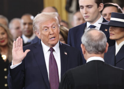 President-elect Donald Trump, from left, takes the oath of office as Barron Trump and Melania Trump watch at the 60th Presidential Inauguration in the Rotunda of the U.S. Capitol in Washington, Monday, Jan. 20, 2025. (Kevin Lamarque/Pool Photo via AP)