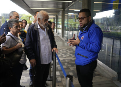 A U.S. consular official explains to people with scheduled visa document submissions that their appointments were canceled due to Colombian President Gustavo Petro's refusal to accept repatriation flights of Colombian citizens from the U.S., at a U.S. Embassy Applicant Service Center in Bogota, Colombia, Monday, Jan. 27, 2025. (AP Photo/Fernando Vergara)