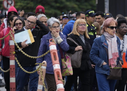 People stand outside the U.S. embassy in Bogota, Colombia, Monday, Jan. 27, 2025, where they were notified their visa appointments were canceled due to Colombian President Gustavo Petro's refusal to accept repatriation flights of Colombian citizens from the United States. (AP Photo/Fernando Vergara)