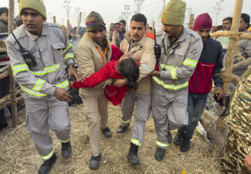 Security officers carry a woman out from the site of a stampede at the Sangam, the confluence of the Ganges, the Yamuna and the mythical Saraswati rivers, on 