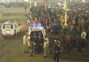 Security officers guide devotees into an ambulance at the site of a stampede on the Sangam, the confluence of the Ganges, the Yamuna and the mythical Saraswati rivers, on 