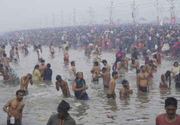 Hindu devotees take a holy dip by the banks of the Sangam, the confluence of the Ganges, the Yamuna and the mythical Saraswati rivers, on 
