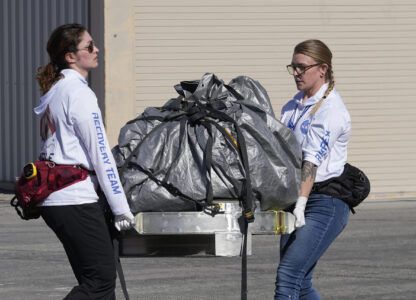 FILE - Recovery team members carry a capsule containing NASA's first asteroid samples to a temporary clean room at Dugway Proving Ground in Utah on Sept. 24, 2023. (AP Photo/Rick Bowmer, Pool, file)