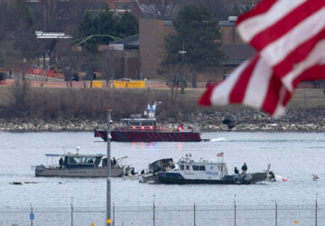 A diving team and police boat is seen around a wreckage site in the Potomac River from Ronald Reagan Washington National Airport, Thursday, Jan. 30, 2025, in Arlington, Va. (AP Photo/Jose Luis Magana)