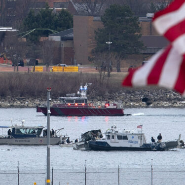 A diving team and police boat is seen around a wreckage site in the Potomac River from Ronald Reagan Washington National Airport, Thursday, Jan. 30, 2025, in Arlington, Va. (AP Photo/Jose Luis Magana)