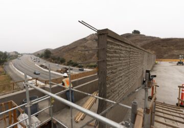 FILE - A construction worker looks over the 101 Freeway from the Wallis Annenberg Wildlife Crossing in Agoura Hills, Calif., Oct. 15, 2024. (AP Photo/Jae C. Hong, File)