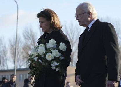 Sweden's King Carl XVI Gustaf and Queen Silvia arrive to place flowers at a memorial near the scene of a shooting on the outskirts of Orebro, Sweden, Wednesday, Feb. 5, 2025. (AP Photo/Sergei Grits)