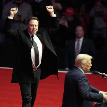 FILE - Elon Musk reacts as President-elect Donald Trump speaks at a rally ahead of the 60th Presidential Inauguration, Jan. 19, 2025, in Washington. (AP Photo/Alex Brandon, File)