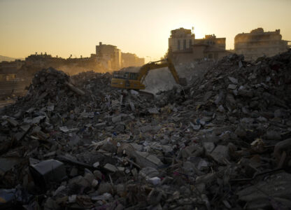 FILE - An excavator digs in the rubble of destroyed buildings in Iskenderun city, southern Turkey, Tuesday, Feb. 14, 2023. (AP Photo/Francisco Seco, File)