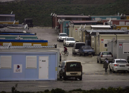 FILE - A boy rides his bicycle among containers homes sheltering survivors of the powerful Feb. 6, 2023 earthquake, in Antakya, southern Turkey, Friday, Jan. 12, 2024. (AP Photo/Khalil Hamra, File)