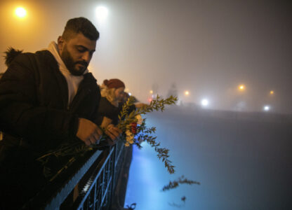 FILE - People toss carnations into the Orontes River as they mark the one-year anniversary of the country's catastrophic earthquake, in the city of Antakya, southern Turkey, Tuesday, Feb. 6, 2024. (AP Photo/Metin Yoksu, File)