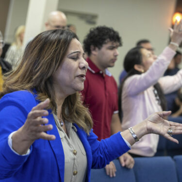 Fatima Guzman prays during a church service at the Centro Cristiano El Pan de Vida, a mid-size Church of God of Prophecy congregation in Kissimmee, Florida, Sunday, Feb. 2, 2025. (AP Photo/Alan Youngblood)
