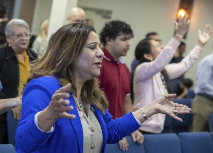 Fatima Guzman prays during a church service at the Centro Cristiano El Pan de Vida, a mid-size Church of God of Prophecy congregation in Kissimmee, Florida, Sunday, Feb. 2, 2025. (AP Photo/Alan Youngblood)
