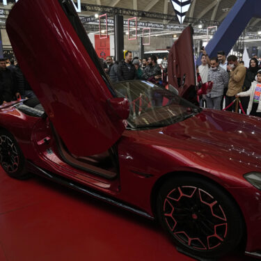 Visitors gather around a car on display at the 6th International Tehran Auto Show and related industries, just outside Tehran, Iran, Thursday, Jan. 30, 2025. (AP Photo/Vahid Salemi)