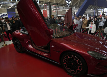 Visitors gather around a car on display at the 6th International Tehran Auto Show and related industries, just outside Tehran, Iran, Thursday, Jan. 30, 2025. (AP Photo/Vahid Salemi)