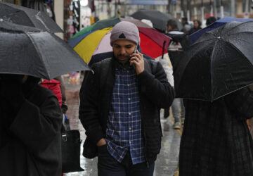 A man speaks on his cellphone while walking on a sidewalk in northern Tehran, Iran, Monday, Jan. 27, 2025. (AP Photo/Vahid Salemi)