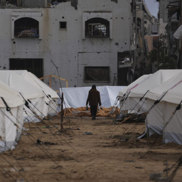 FILE - A man walks between tents for displaced Palestinians next to destroyed buildings following the Israeli air and ground offensive in Jabaliya, Gaza Strip, Thursday, Feb. 6, 2025. (AP Photo/Abdel Kareem Hana, file)