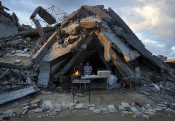 FILE - A man sells bread under the ruin of his bakery destroyed by the Israeli air and ground offensive in Jabaliya, Gaza Strip, Wednesday, Feb. 5, 2025. (AP Photo/Abdel Kareem Hana, file)