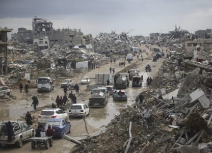 FILE - Cars and pedestrians move along a road amid widespread destruction caused by the Israeli military's ground and air offensive against Hamas in Gaza City's Jabaliya refugee camp, Friday, Feb. 7, 2025. (AP Photo/Jehad Alshrafi, file)