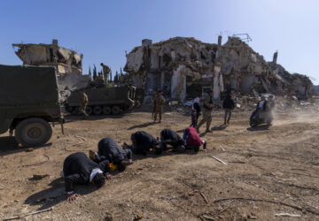 Lebanese men pray after they entered their destroyed hometown of Kfar Kila, southern Lebanon, Tuesday, Feb. 18, 2025. (AP Photo/Hassan Ammar)