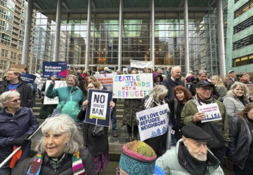 People gather outside the U.S. District Court after a federal judge blocked President Donald Trump's effort to halt the nation's refugee admissions system Tuesday, Feb. 25, 2025, in Seattle. (AP Photo/Eugene Johnson)