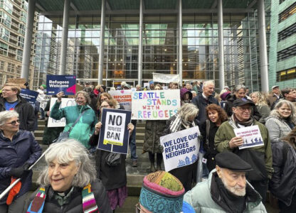 People gather outside the U.S. District Court after a federal judge blocked President Donald Trump's effort to halt the nation's refugee admissions system Tuesday, Feb. 25, 2025, in Seattle. (AP Photo/Eugene Johnson)