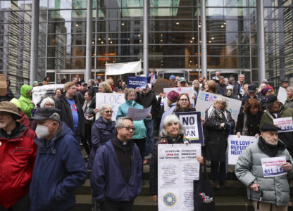 People gather outside the U.S. District Court after a federal judge blocked President Donald Trump's effort to halt the nation's refugee admissions system Tuesday, Feb. 25, 2025, in Seattle. (AP Photo/Ryan Sun)