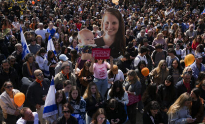 People watch a live broadcast from the funeral of slain hostages Shiri Bibas and her two children, Ariel and Kfir, at a plaza known as the Hostages Square in Tel Aviv, Israel, Wednesday, Feb. 26, 2025. The mother and her two children were abducted by Hamas on Oct. 7, 2023, and their remains were returned from Gaza to Israel last week as part of a ceasefire agreement with Hamas. (AP Photo/Ariel Schalit)