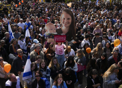 People watch a live broadcast from the funeral of slain hostages Shiri Bibas and her two children, Ariel and Kfir, at a plaza known as the Hostages Square in Tel Aviv, Israel, Wednesday, Feb. 26, 2025. The mother and her two children were abducted by Hamas on Oct. 7, 2023, and their remains were returned from Gaza to Israel last week as part of a ceasefire agreement with Hamas. (AP Photo/Ariel Schalit)