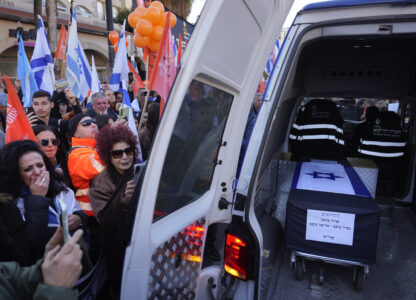 Mourners gather around the car carrying the coffins of slain hostages Shiri Bibas and her two children, Ariel and Kfir, during their funeral procession in Rishon Lezion, Israel, Wednesday, Feb. 26, 2025. The mother and her two children were abducted by Hamas on Oct. 7, 2023, and their remains were returned from Gaza to Israel last week as part of a ceasefire agreement with Hamas. (AP Photo/Ariel Schalit)