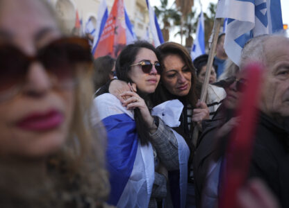 Mourners react as the convoy carrying the coffins of slain hostages Shiri Bibas and her two children, Ariel and Kfir, passes by during their funeral procession in Rishon Lezion, Israel, Wednesday, Feb. 26, 2025. The mother and her two children were abducted by Hamas on Oct. 7, 2023, and their remains were returned from Gaza to Israel last week as part of a ceasefire agreement with Hamas. (AP Photo/Ariel Schalit)