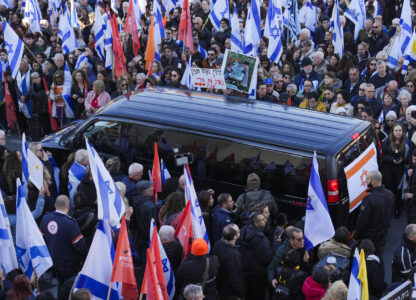 Mourners gather around the convoy carrying the coffins of slain hostages Shiri Bibas and her two children, Ariel and Kfir, during their funeral procession in Rishon Lezion, Israel, Wednesday, Feb. 26, 2025. The mother and her two children were abducted by Hamas on Oct. 7, 2023, and their remains were returned from Gaza to Israel last week as part of a ceasefire agreement with Hamas. (AP Photo/Ariel Schalit)