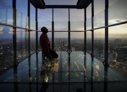 FILE - A man looks at members of the Malaysian Islamic authority as they perform the 