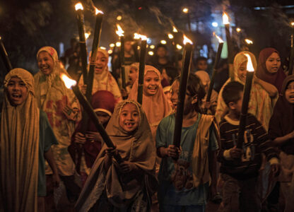 FILE - Muslim girls carry torches during a parade to celebrate the eve of Eid al-Fitr, the holiday marking the end of the holy fasting month of Ramadan, in Polewali Mandar, West Sulawesi, Indonesia, Friday, April 21, 2023. (AP Photo/Yusuf Wahil, File)