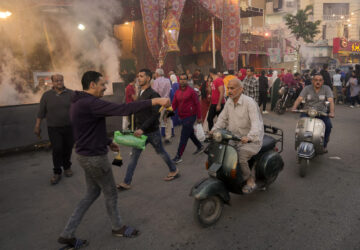 FILE - A volunteer distributes free juice ahead of Iftar, the evening meal breaking the Ramadan fast, at El-Gamaliyya district in Cairo, Egypt Friday, April 14, 2023. (AP Photo/Amr Nabil, File)