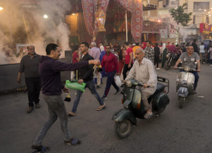 FILE - A volunteer distributes free juice ahead of Iftar, the evening meal breaking the Ramadan fast, at El-Gamaliyya district in Cairo, Egypt Friday, April 14, 2023. (AP Photo/Amr Nabil, File)