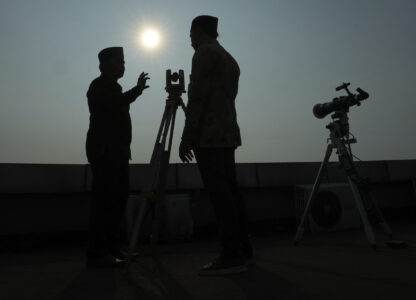 FILE - Officials are silhouetted as they use a telescope to scan the horizon for a crescent moon that will determine the beginning of the holy fasting month of Ramadan in Jakarta, Indonesia, Wednesday, March. 22, 2023. (AP Photo/Achmad Ibrahim, File)